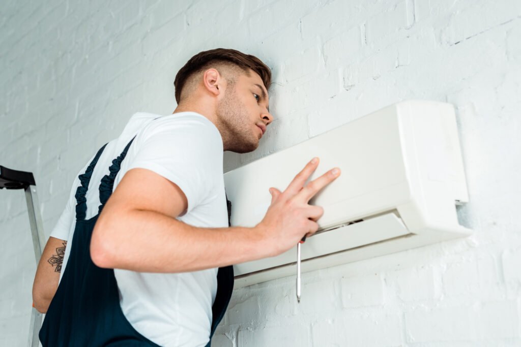 Technician installing air conditioner